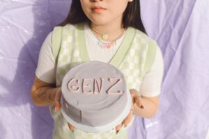 Chica cogiendo una tarta con "GEN Z" en ella
