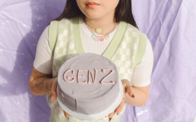 Chica cogiendo una tarta con "GEN Z" en ella