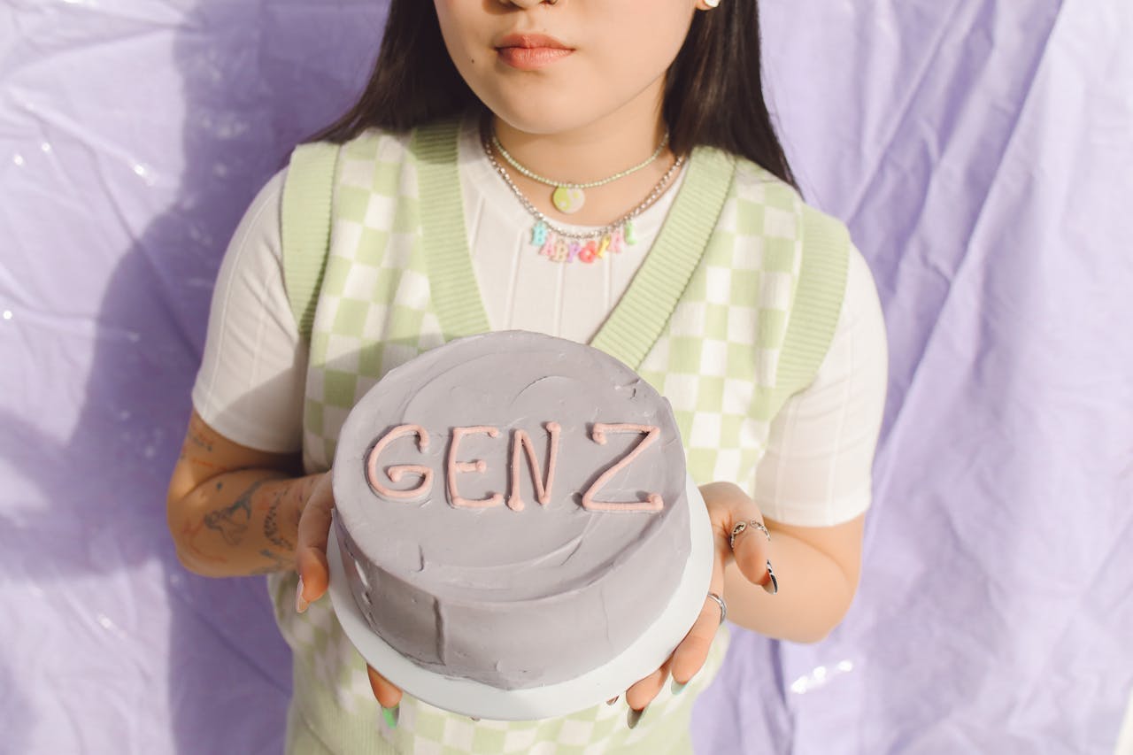 Chica cogiendo una tarta con "GEN Z" en ella
